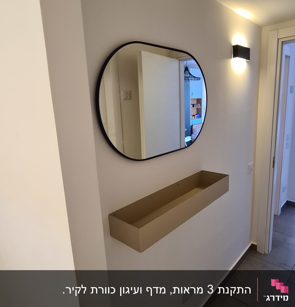 מראה עגולה תלויה על קיר עם מדף מתחת